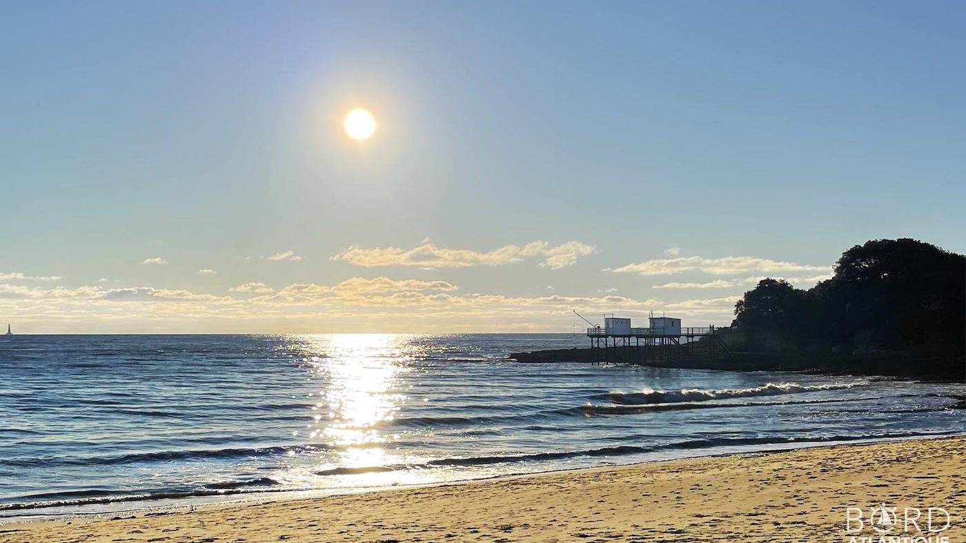 Contre-jour sur la plage du Platin à Saint-Palais-sur-Mer, avec les carrelets sur pilotis à droite du cadre